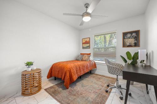 een slaapkamer met een bed met een oranje sprei en een bureau bij Austin Dunstan by Barclé in Austin