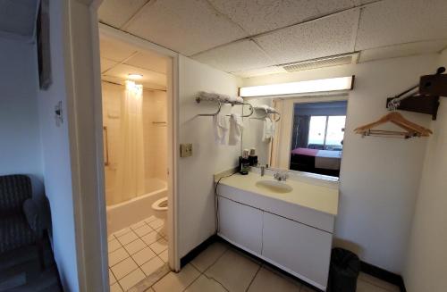 uma casa de banho com um lavatório, um chuveiro e um WC. em Newburgh Inn em Newburgh