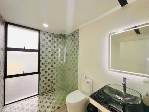 a bathroom with a sink and a toilet and a window at Villas Paraiso, Junquillal, Santa Cruz Desconectate en el Paraiso in Paraíso