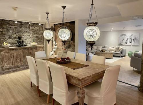 a dining room with a wooden table and white chairs at Exclusive 6 bed, 6 bath residence in Old Montreal in Montréal
