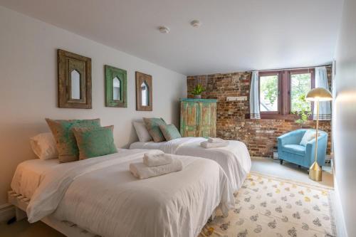 2 ampi letti in una camera da letto con sedia blu di Exclusive 6 bed, 6 bath residence in Old Montreal a Montréal