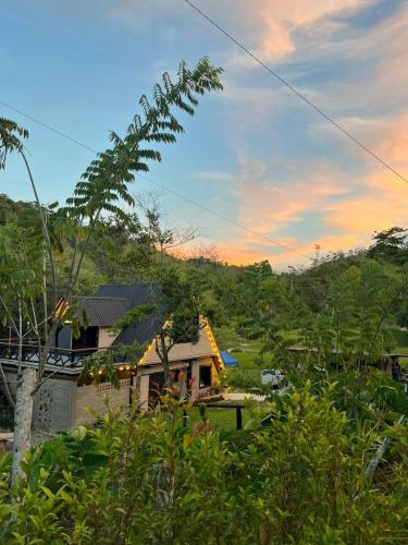 a house with a sunset in the background at Isla Escondida Maceo Finca Hotel y Restaurante in Yolombó