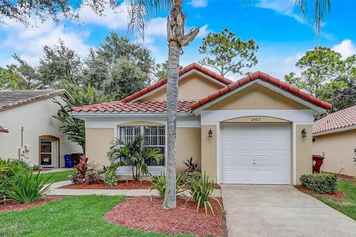 a house with a palm tree in front of it at The Par-fect Getaway in Haines City