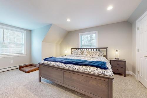 a bedroom with a large bed and two windows at Modern Mountain Homestead in Dover