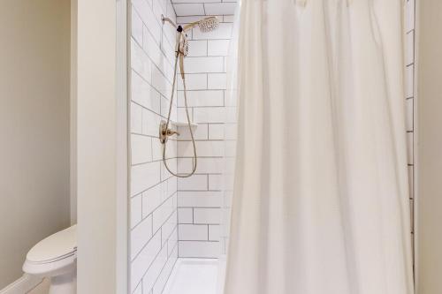 e bagno con doccia con tenda bianca. di Modern Mountain Homestead a Dover