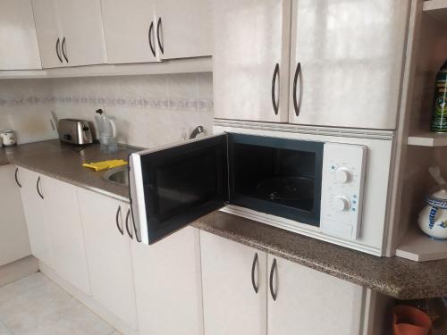 a microwave in a kitchen with a sink at Habitacion Privada Doble en Toledo in Toledo