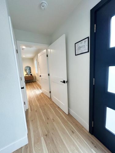 an empty hallway with a blue door and wooden floors at New Haven Inn in Solvang