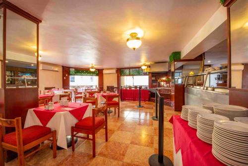 a restaurant with tables and chairs with plates on them at Hotel del Gobernador in Mérida