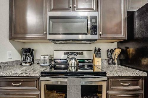 a kitchen with a stove and a microwave at 2 Community Pools-Fully Stocked for Longer Stays in Mesa
