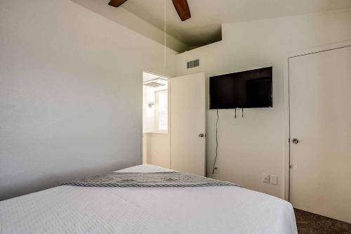 a white bedroom with a bed and a flat screen tv at 2 Community Pools-Fully Stocked for Longer Stays in Mesa