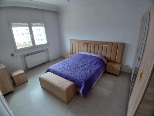 a bedroom with a bed and a chair and two windows at calm inn Centre Urbain Nord in Ariana