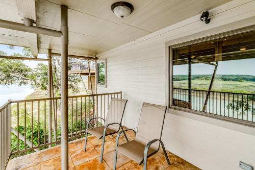 two chairs sitting on the balcony of a house at Harbor Point in Spicewood