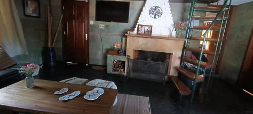 uma sala de estar com uma mesa e uma lareira em Cabaña en El Pinar em El Pinar