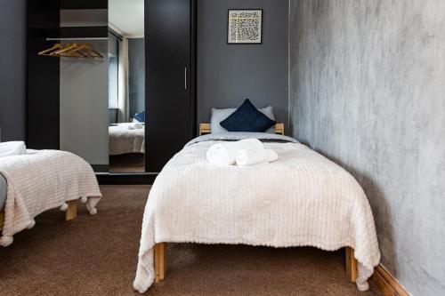 um quarto com uma cama com duas toalhas em LARGE 3 bed house IDEAL for Contractors or family - M1 Nottingham em Nottingham