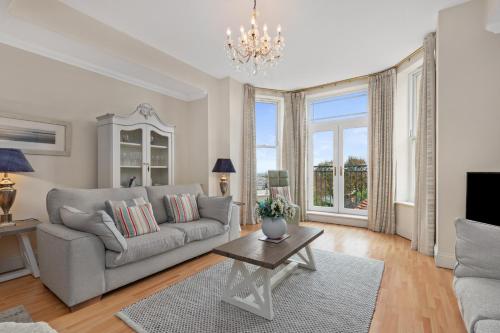 a living room with a couch and a table at Bryn Y Mor - Tenby Apartment Sea Views in Tenby