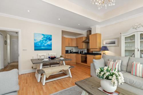 a living room with a couch and a table at Bryn Y Mor - Tenby Apartment Sea Views in Tenby
