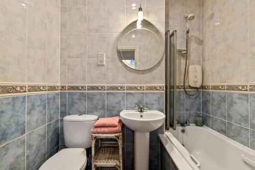 a bathroom with a toilet and a sink and a tub at Bryn Y Mor - Tenby Apartment Sea Views in Tenby