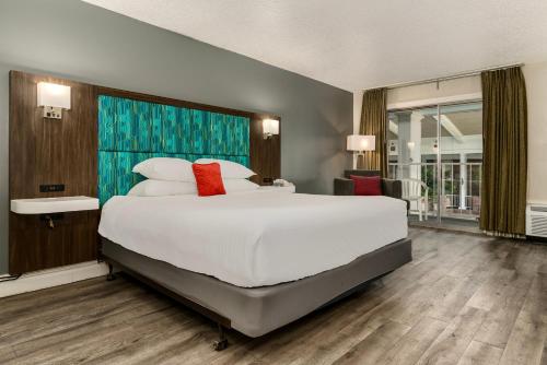 Red Lion Hotel Pocatello في بوكاتيلو: غرفة نوم كبيرة مع سرير أبيض كبير مع وسائد حمراء
