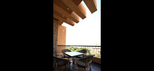 a table and chairs on a balcony with a window at Maison 7 New Cairo in Cairo