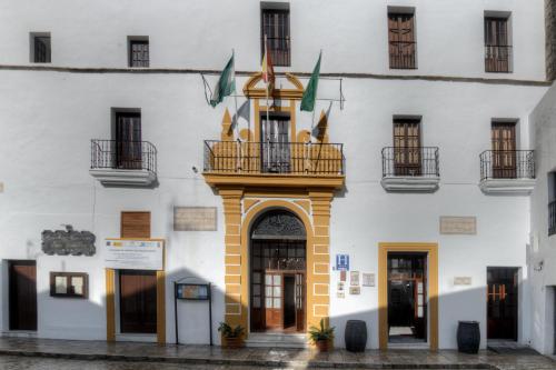 eine Fassade eines Gebäudes mit Balkon in der Unterkunft Hotel Tugasa Convento San Francisco in Vejer de la Frontera