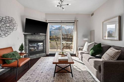 a living room with a couch and a fireplace at Luxury 3B Mountain Views- Pool & Hot Tub -Sleeps 10 in Canmore