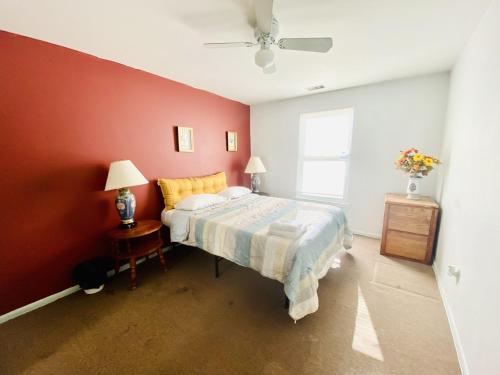 a bedroom with a bed and a red wall at Airport Xpress Guestrooms in Philadelphia