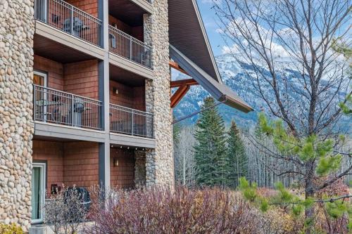 a apartment building with a balcony with a view of the mountains at Luxury 3B Mountain Views- Pool & Hot Tub -Sleeps 10 in Canmore