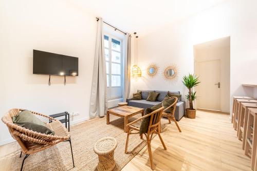 a living room with a couch and a tv at Les Suites de l'Opéra appartement Barbara 10 pers in Lyon