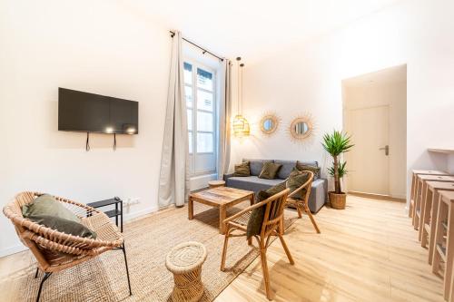 un salon avec un canapé et une télévision dans l'établissement Les Suites de l'Opéra - Apartment Barbara for 10 people, à Lyon