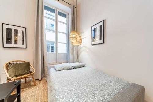 une chambre avec un lit, une chaise et une fenêtre dans l'établissement Les Suites de l'Opéra - Apartment Nina for 6 people, à Lyon