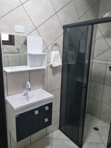 uma casa de banho com um lavatório e um chuveiro em Hostel Anprado em Guarulhos