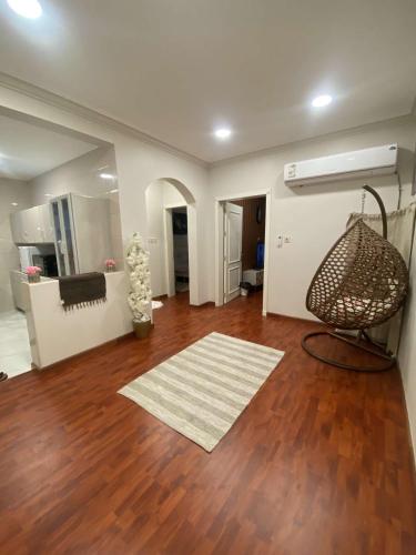 sala de estar con suelo de madera y espejo en شقة مكونة من صالة وغرفة نوم, en Al Hofuf