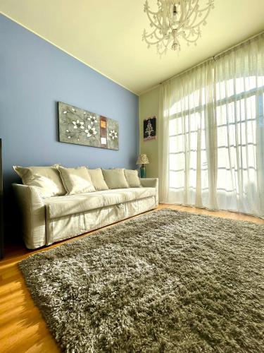 - un salon avec un canapé et un tapis dans l'établissement Luxury Four-Room Apartment in Monza Centro - 2 min walk to Train Station, à Monza