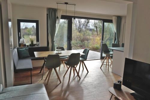 a living room with a dining room table and chairs at FeWo EG am Fluss mit Terrasse - eine grüne Oase 