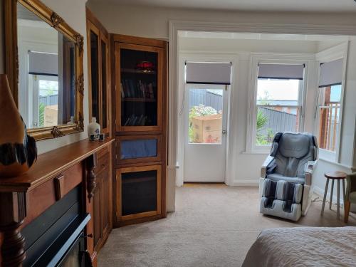 a room with a bedroom with a mirror and a chair at Lords Rest Apartment - Private and Central with Free Parking and Great WIFI in Hobart