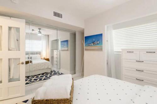 Habitación blanca con cama y espejo en Perfect Beach Escape 1BD/1Bath Close to Everything, en Fort Lauderdale