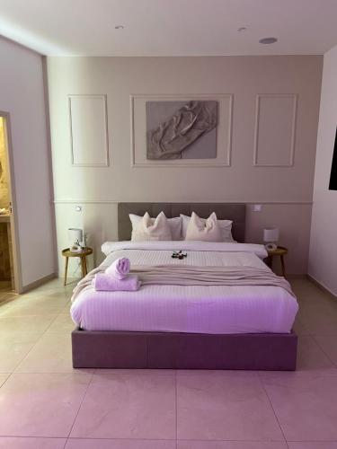 een slaapkamer met een groot bed met paarse lakens bij Suite Marajah in Le Pontet