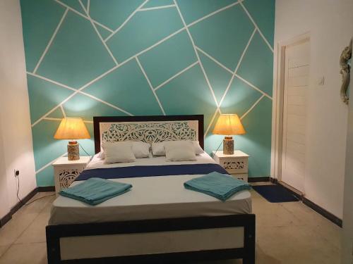 a bedroom with a large bed with two lamps at River Front Villa in Wadduwa