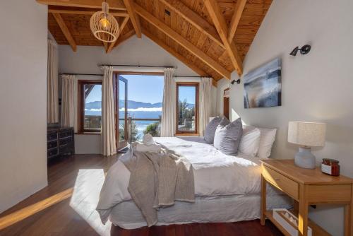 a bedroom with a bed with a view of the ocean at Lake Hawea View in Albert Town