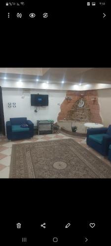 een woonkamer met blauwe banken en een tv bij elkasr elmalaki in Alexandrië