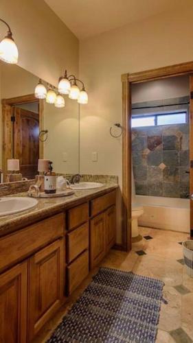 a bathroom with two sinks and a large mirror at Torreon Family Cabin Large Decks and Open Floorplan in Show Low