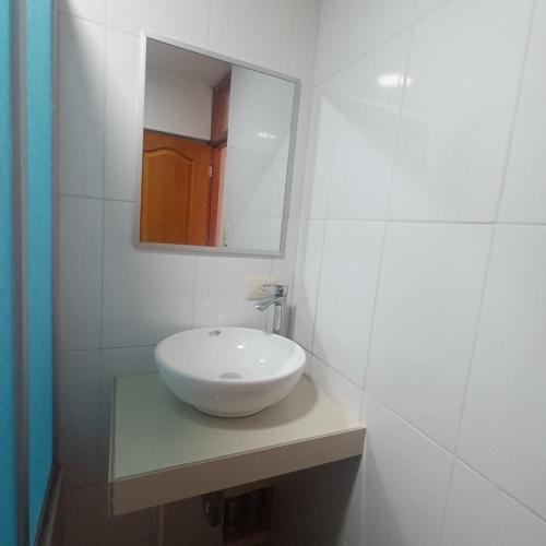 uma casa de banho com um lavatório branco e um espelho. em VILLA MARAS Hotel em Maras