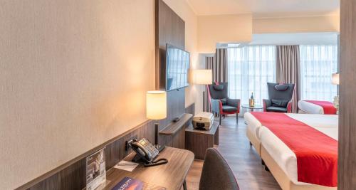 een hotelkamer met een bed, een bureau en stoelen bij Best Western Plus Plaza Den Haag City Center in Den Haag