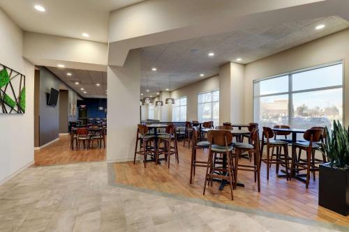 a restaurant with tables and chairs and a large window at Drury Plaza Hotel Denver Westminster in Westminster