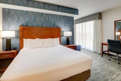 a bedroom with a bed and a desk and a chair at Drury Plaza Hotel Denver Westminster in Westminster