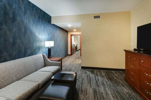 a living room with a couch and a flat screen tv at Drury Plaza Hotel Denver Westminster in Westminster