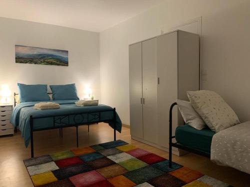 a bedroom with a bed and a cabinet and a rug at Chambres Senonches centre-ville in Senonches