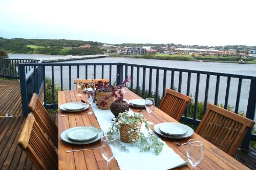 a wooden table on a balcony with a view of the water at Riverview in Warrnambool