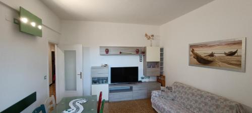 een woonkamer met een bank en een flatscreen-tv bij Sonia's house in Albissola Marina