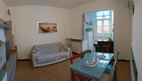 een woonkamer met een tafel en een bank bij Sonia's house in Albissola Marina